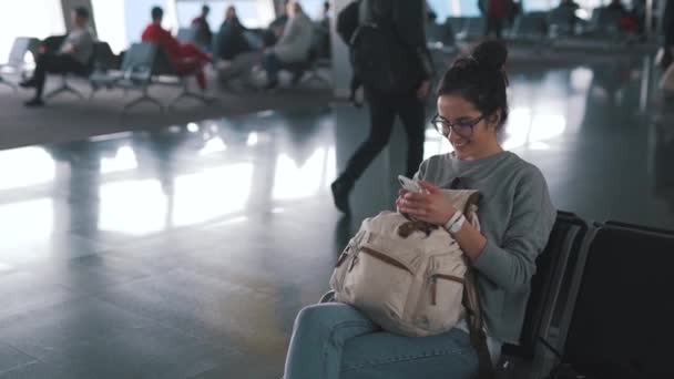 Turista chica utiliza smartphone en aeropuerto salón — Vídeos de Stock