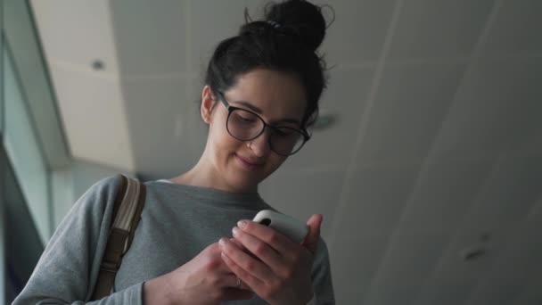 Menina usa smartphone no lounge do aeroporto — Vídeo de Stock