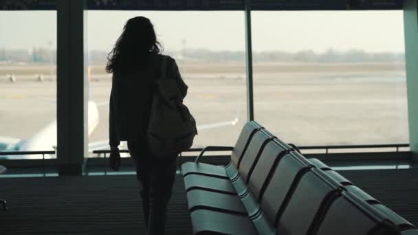 Chica con una mochila esperando un vuelo — Vídeos de Stock