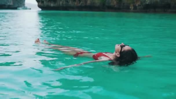 Girl swims in turquoise water close-up — Stock Video