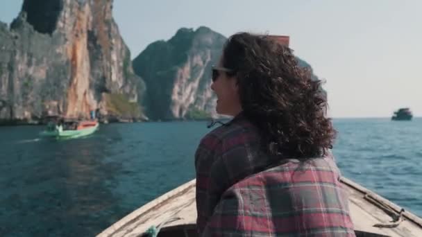 Dívka jede lodí ke skalám v oceánu — Stock video
