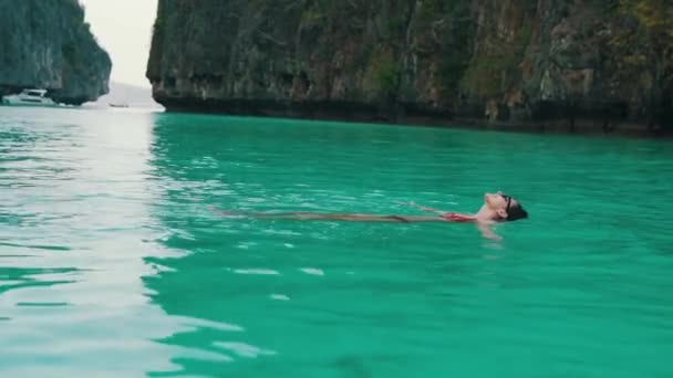 Девушка плавает в бирюзовой воде в заливе — стоковое видео