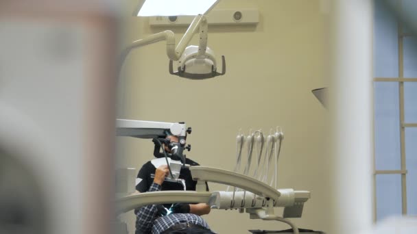 Стоматолог, работающий с клиентом в клинике — стоковое видео