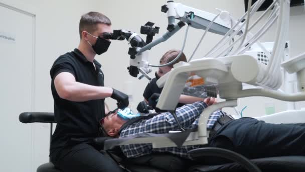 Dentysta wykorzystuje sprzęt technologiczny podczas zabiegu chirurgicznego — Wideo stockowe