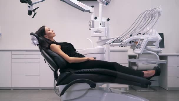 Diş kliniğinde bir sandalyede yatan kız — Stok video