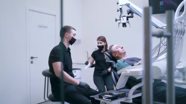 Tandläkare med assistent gör kirurgi — Stockvideo