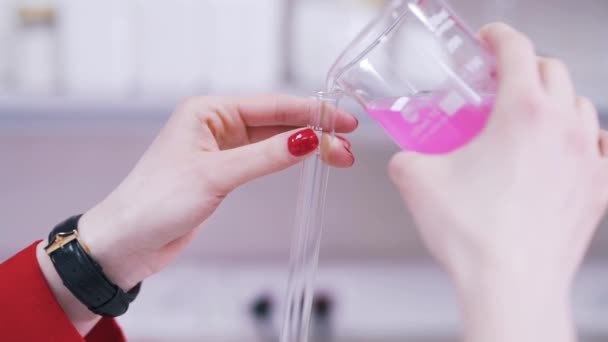 Ученый наливает жидкость в пробирку — стоковое видео
