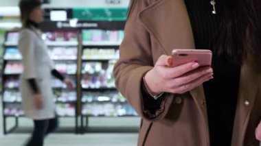 kız mağazada telefon kullanır