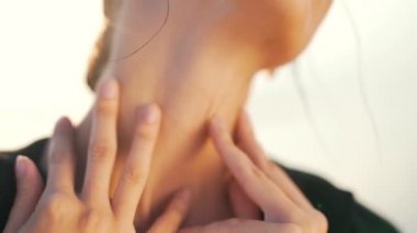 Kız boynunu sıkıca okşuyor.