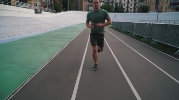 Adam şehirde koşu bandında koşuyor. — Stok video
