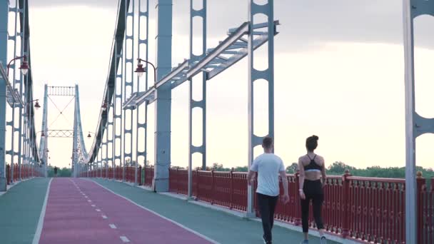 Deportes pareja camina en el puente — Vídeo de stock