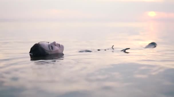 Meisjes liggen op hun rug in het water — Stockvideo