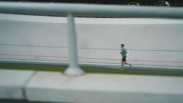 Tipo corre en una pista de ciclismo en la ciudad — Vídeos de Stock