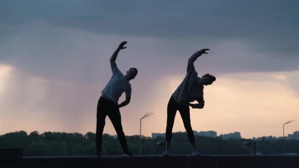 Par gör sport på bakgrunden av staden — Stockvideo