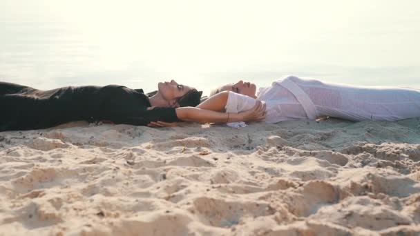 Menina tocar uns aos outros deitado na areia — Vídeo de Stock