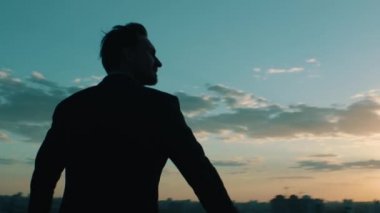 İş adamı şehre bir gökdelenin çatısından bakıyor.