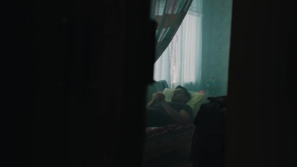Ένας άντρας αναπαύεται σε ένα παλιό διαμέρισμα της πρώην Σοβιετικής Ένωσης. — Αρχείο Βίντεο