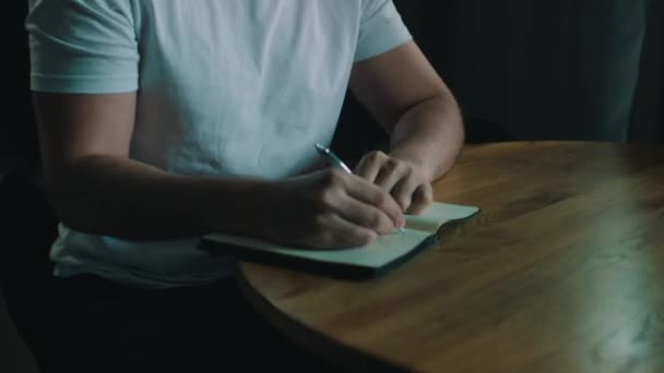 Hombre escribe ideas en un cuaderno — Vídeo de stock