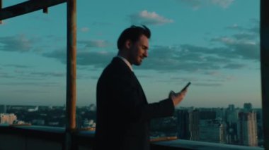 Üst düzey yönetici şehir manzaralı bir akıllı telefon kullanıyor