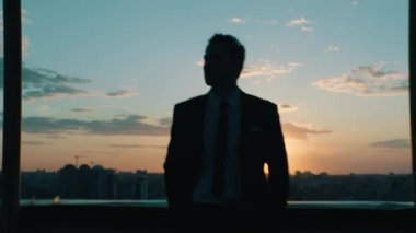 Günbatımında şehrin arka planına karşı bir çalışma gününden sonra yönetici