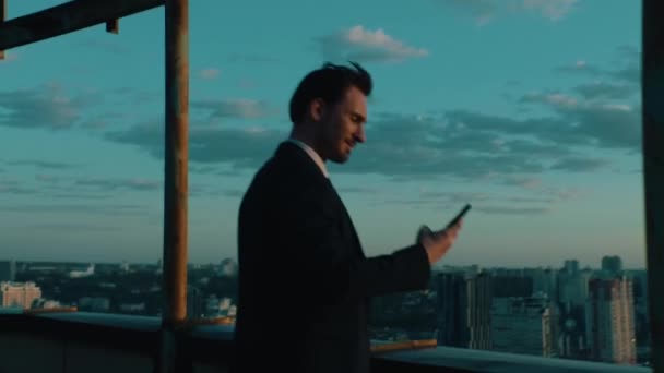 Top-Manager nutzt Smartphone mit Blick auf die Stadt — Stockvideo