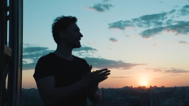 Homme frotte ses mains avec inspiration en regardant la ville d'une hauteur — Video