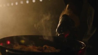 Şef kızartma tavasında erişte hazırlıyor.