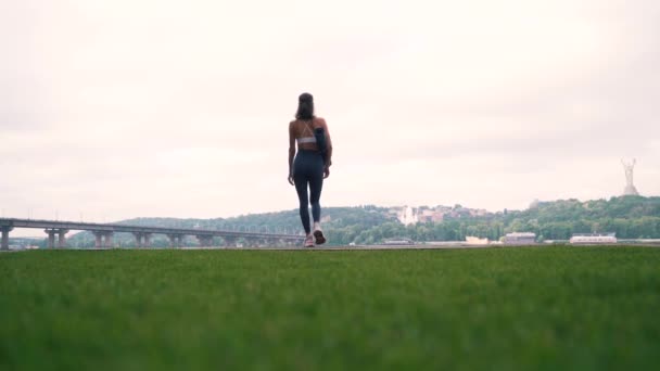 都会の背景にフィットネスマットを持つ女の子 — ストック動画