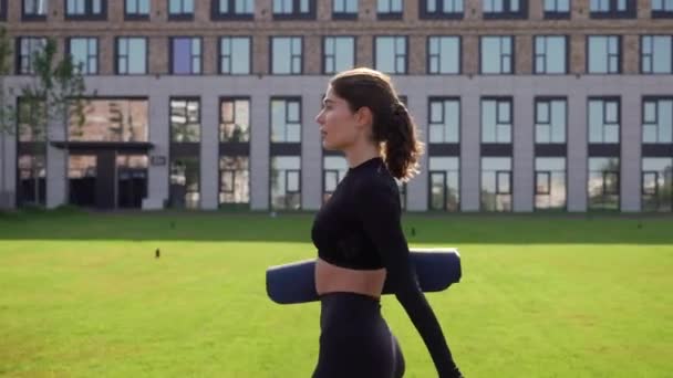 Barfüßiges Mädchen geht mit Fitnessmatte — Stockvideo