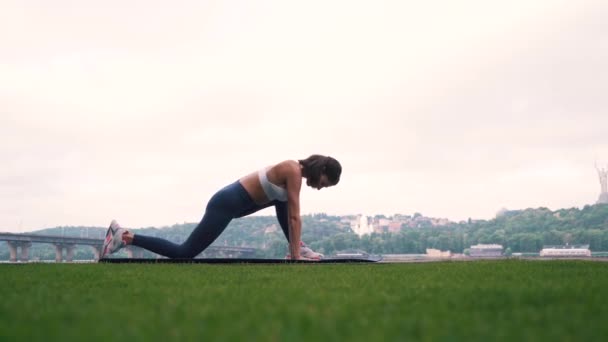 La jeune fille est engagée dans la forme physique sur le fond de la ville — Video