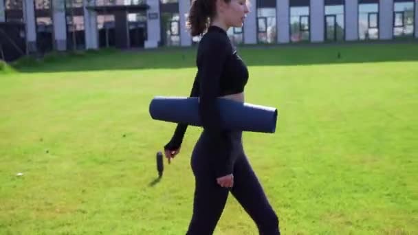 Kız dışarıda spor paspasıyla yürüyor. — Stok video