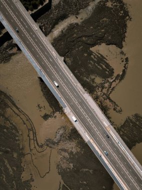 Çamurlu nehir manzarası üzerindeki köprünün havadan görünüşü