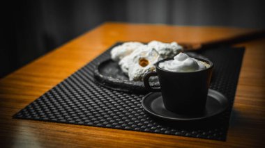 Kahve fincanı ve hamur işleri ahşap masada yakın plan.