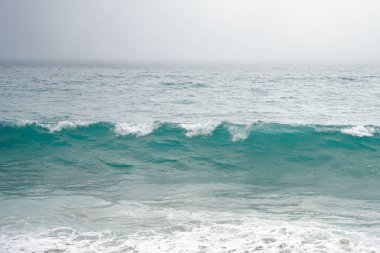 Dalgalar sakin okyanus yüzeyine yavaşça çarpıyor. 