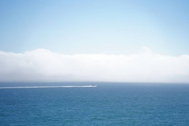 Tekne sakin mavi okyanus sularında yüzüyor.
