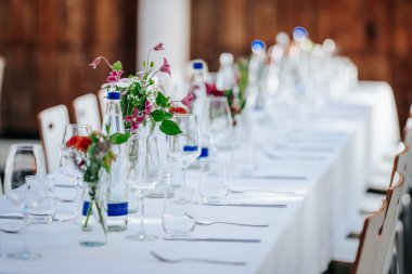 Çiçekler ve cam süslemelerle süslenmiş zarif yemek masası