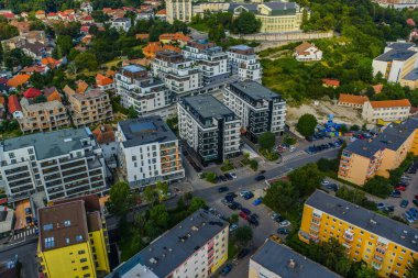Kentsel şehir manzarası çeşitli modern binaları ve yeşil alanları gösteriyor.