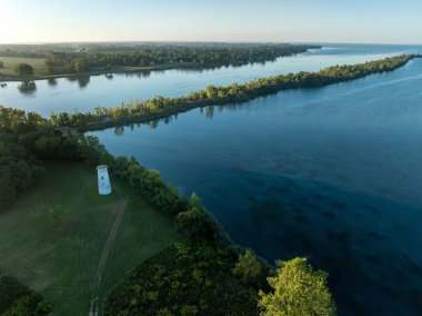 Bereketli yeşil ağaçlar ve açık arazilerle çevrili dolambaçlı bir nehrin havadan görünüşü