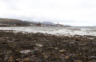 Stormy Seaside Town View with Seaweed kaplı Rocky Shore