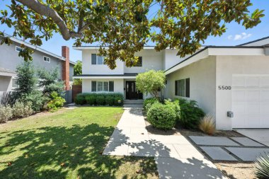 Lush peyzaj ile modern iki katlı bir banliyö evinin dış görünüşü