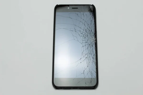 Mobile smartphone with broken screen on white background.