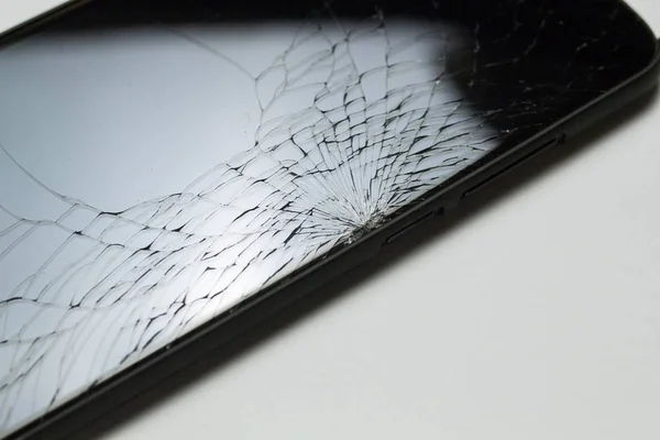 Accidentally cracked, damaged smartphone LCD screen isolated on white background.