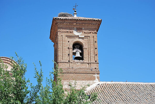 Belfry of the church with the nest of the stork. Bell, nest, cross