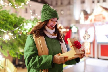 Sürpriz kadın hediye kutusunu açıyor, Noel ağacının yanında duruyor Noel ağacı, Noel ve yeni yıl kutlaması, kış tatili konsepti.
