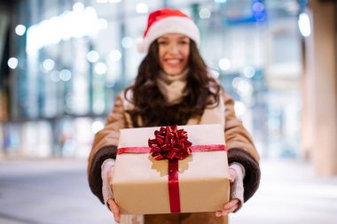 Kamera önünde poz veren, Noel hediyeleri alan hediye kutusundaki kadına odaklan.