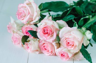 Masanın üzerinde güzel bir buket gül var.