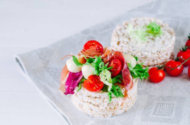 Pirinç keki, marul, mozzarella, domates ve prosciutto ile sağlıklı sandviç