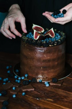 Taze yabanmersini, böğürtlen ve rustik koyu arka plan üzerinde incir ile çikolatalı kek