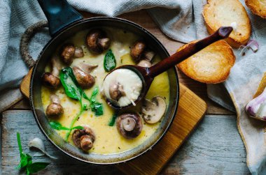 Erime mozzarella tavada mantar, fesleğen ve sarımsak croutons rustik tarzı ahşap bir masa üzerinde 