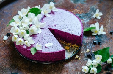 Peynirli kek pişirme olmadan yaban mersini ile Yasemin çiçekleri ile süslenmiş üzerinde eski rustik masaya